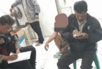 Remaja yang diduga gangster bersenjata tajam diringkus warga Sunter Jaya saat sedang dimintai keterangan oleh petugas kepolisian sektor Tanjung Priok di Pos RT.08. (Foto: news.devilo.co/mgh).